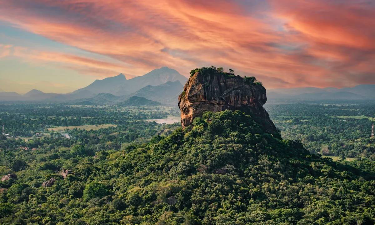 Sigiriya rock rising above forest at sunset